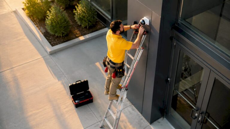 Technician installing security camera at entrance