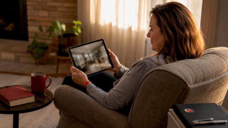 Adult daughter monitoring elderly parent on tablet