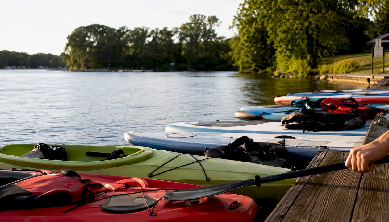Kayaks and paddleboards on river launch