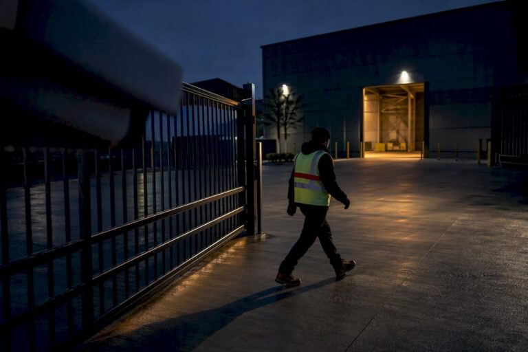 Figure crossing industrial warehouse gate