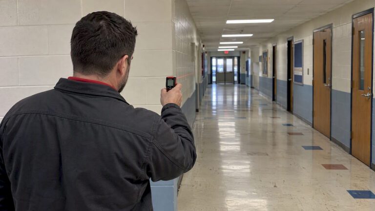 Installer measuring a school corridor sightline