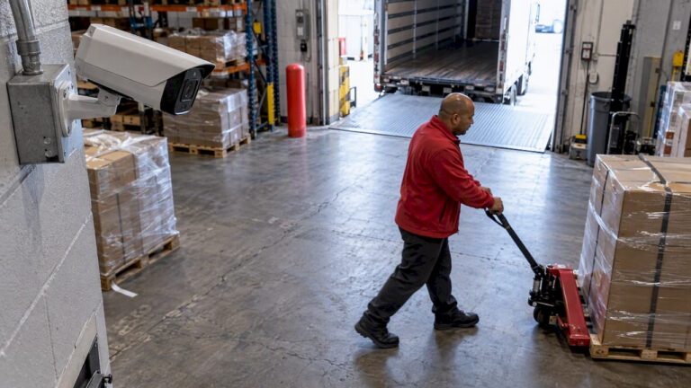 Security camera overlooking a moving warehouse worker